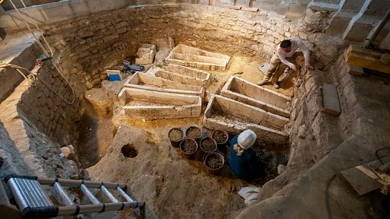 Dégagement des squelettes déposés à l'intérieur des cuves de sarcophages mérovingiens (fin Ve-VIe siècle) lors des fouilles de la basilique de Saint-Denis en mars 2023
