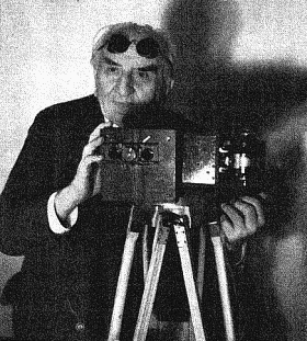 Louis Lumière et son appareil de projection en relief. Il porte les lunettes de spectateur