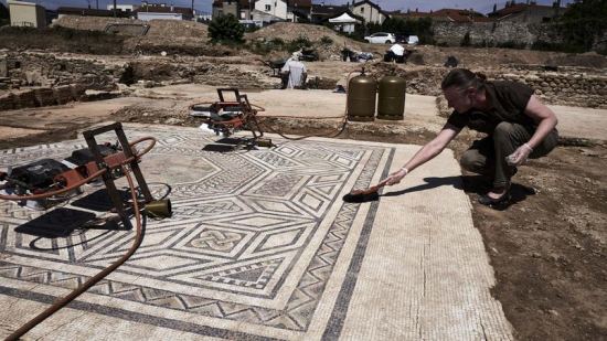 Un archéologue travaille sur une mosaïque après la découverte d'un faubourg entier de la Vienne romaine, le 31 juillet à Sainte-Colombe (Rhône)