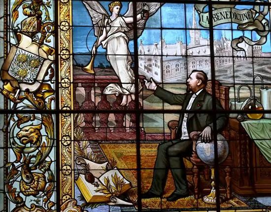 Sur ce vitrail de 1900, Alexandre Le Grand est représenté devant son palais, une main posée sur un globe terrestre évoquant l'internationalisation de sa marque. À ses pieds, le manuscrit contenant la recette qui a fait sa fortune. La bouteille Bénédictine, elle, est confiée à la Renommée, symbole de la réclame