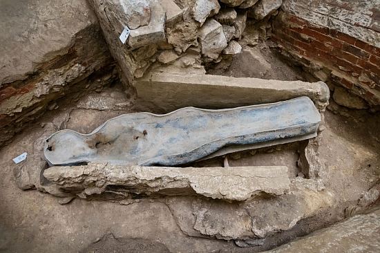 Sarcophage en plomb entouré des carneaux de chauffage du XIXe siècle mis au jour lors de la fouille de la croisée du transept de Notre-Dame de Paris