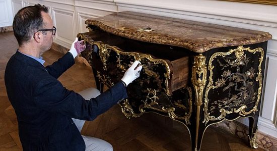 Le directeur du Musée National du château de Versailles, Laurent Salomé, inspecte la magnifique commode du XVIIIe siècle que vient d'acquérir le Musée pour 4 millions d'euros