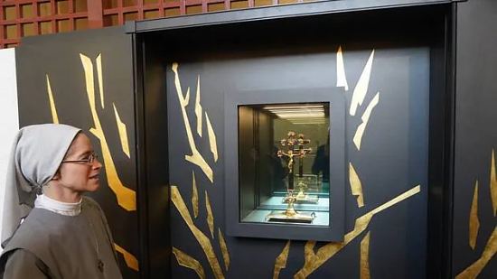 Une sœur de la congrégation des Filles du cœur de Marie devant la Vraie Croix, désormais visible au public dans le sanctuaire de la chapelle de la Girouardière, dans le centre de Baugé