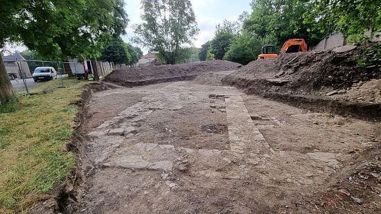 Vue générale de la fouille à l'issue du décapage. La porte du château est visible à l'arrière-plan (à gauche)