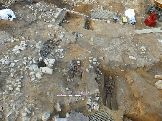 Sépultures installées dans le bâtiment, possible chapelle, avec au centre des fours à cloche du début du XIIIe siècle