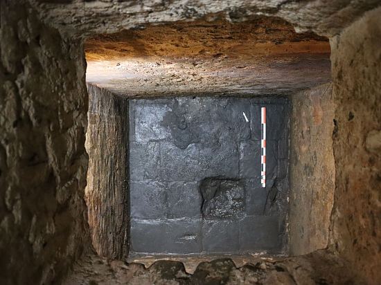 Une fois les couches de matériaux superposés enlevées, la citerne a révélé un sol composé de dalles de schiste