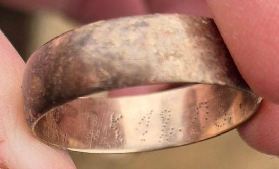 Vue de détail de la bague de la tombe 30. Elle était disposée sur l'un des doigts de la main droite du soldat allemand. Les nombres 25 12 08 sont poinçonnés, correspondant à la date de mariage du défunt, soit le 25 décembre 1908. Les lettres A et X étaient également poinçonnés